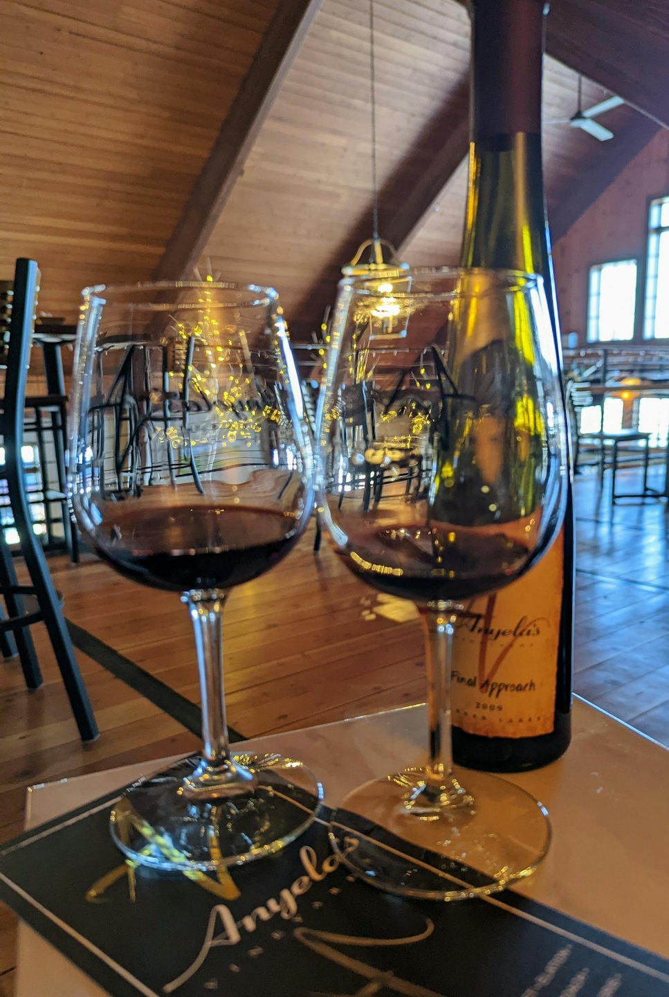 Red wine in a glass and bottle on a wooden table.